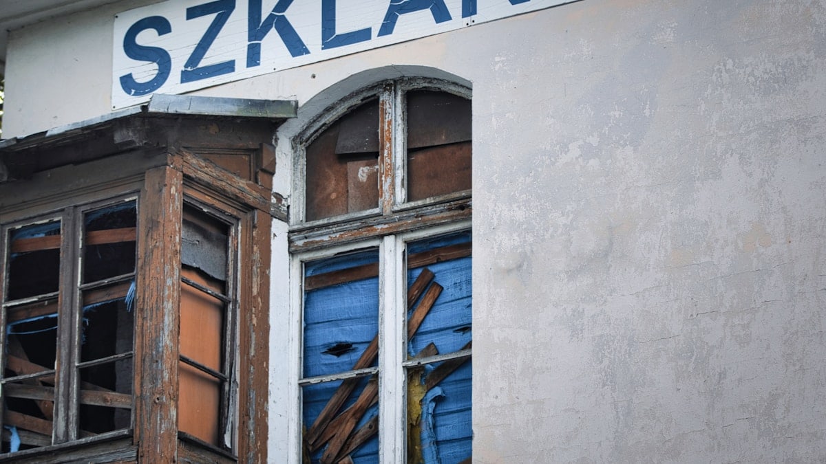 Old building with broken windows and sign